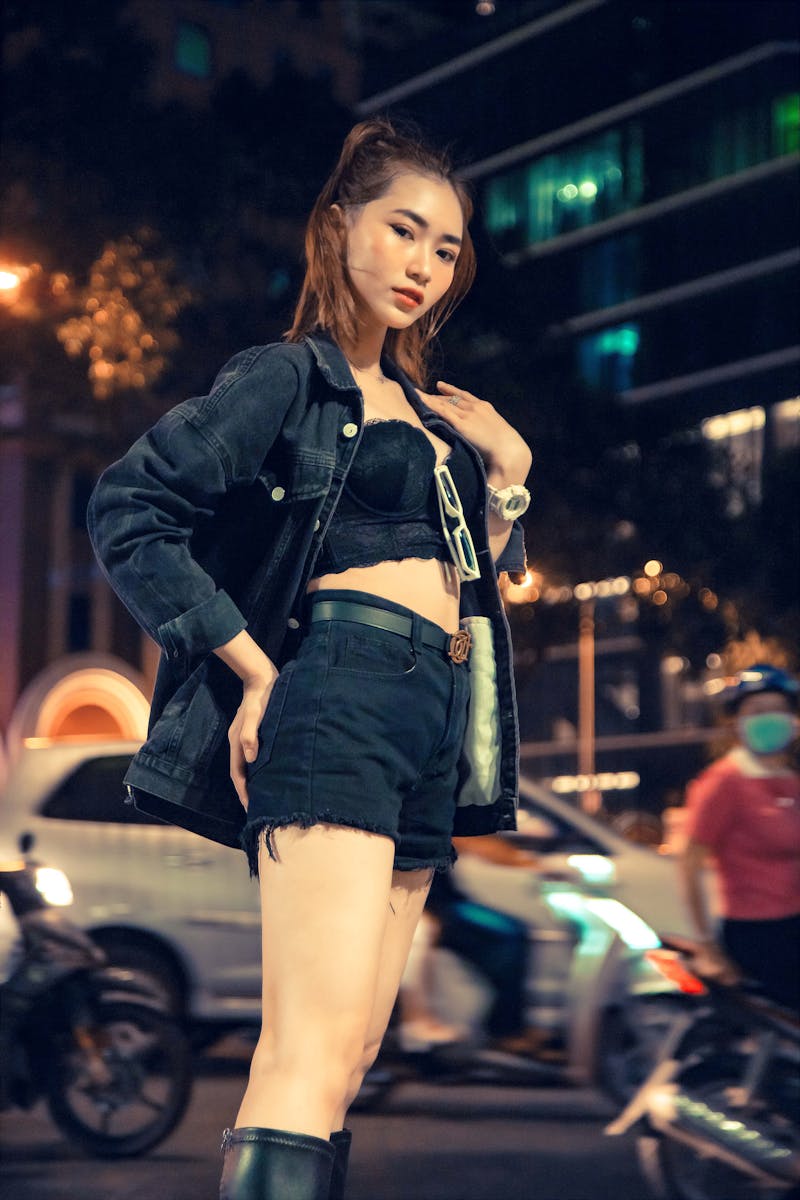 夜の街でポーズするスタイリッシュな若い女性