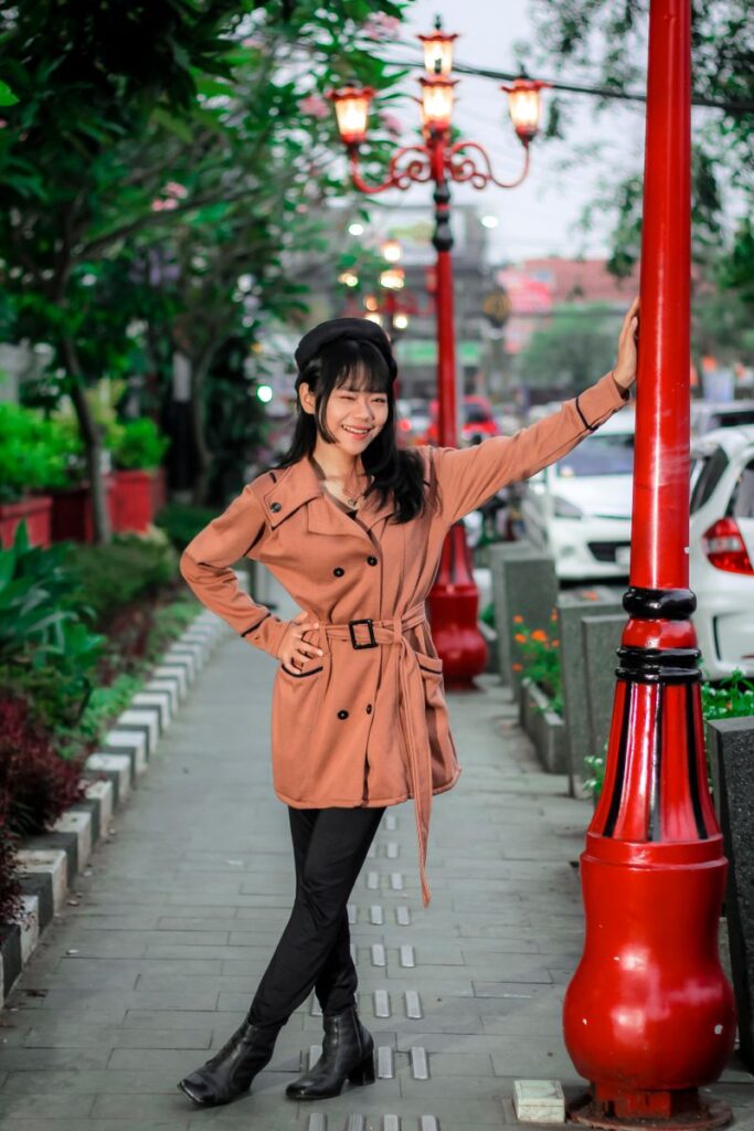 おしゃれなコートで街を歩く若い女性