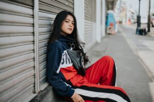 ストリートウェアでラフにポーズする若い女性