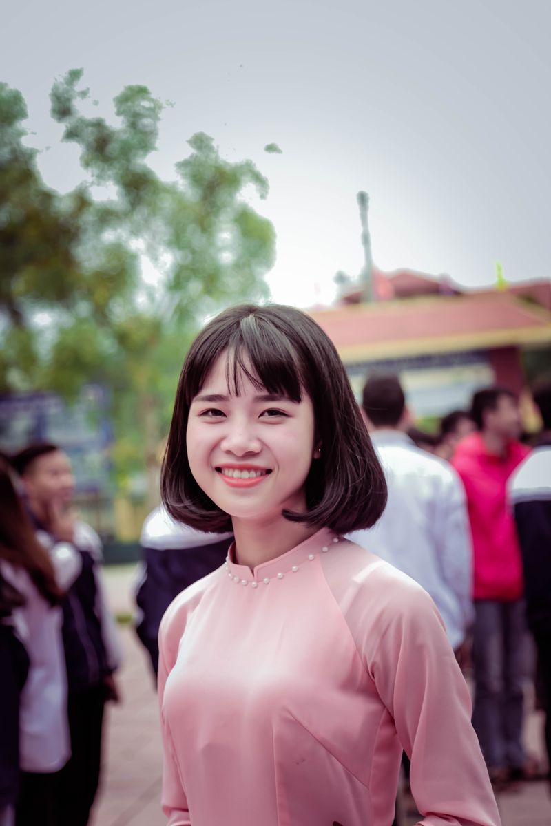 ピンクのワンピースで笑顔の明るい若い女性